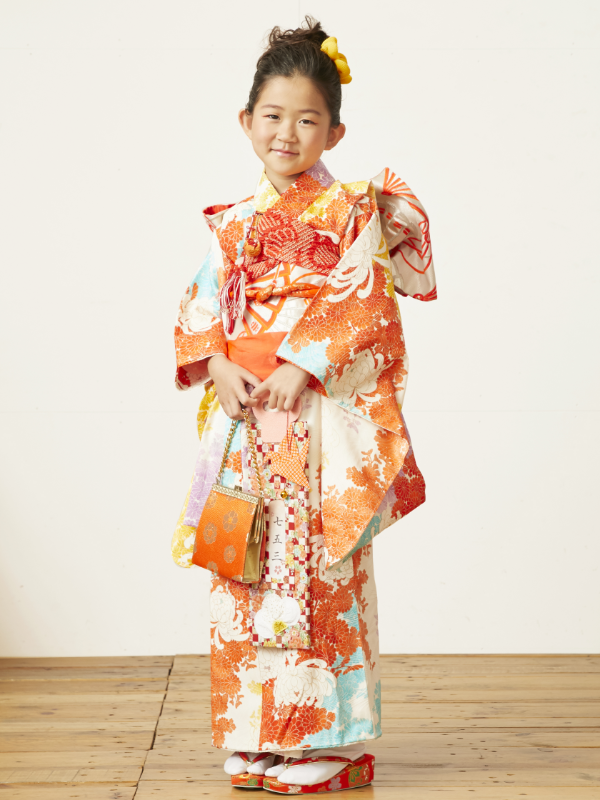 girl standing holding orange bag wearing orange